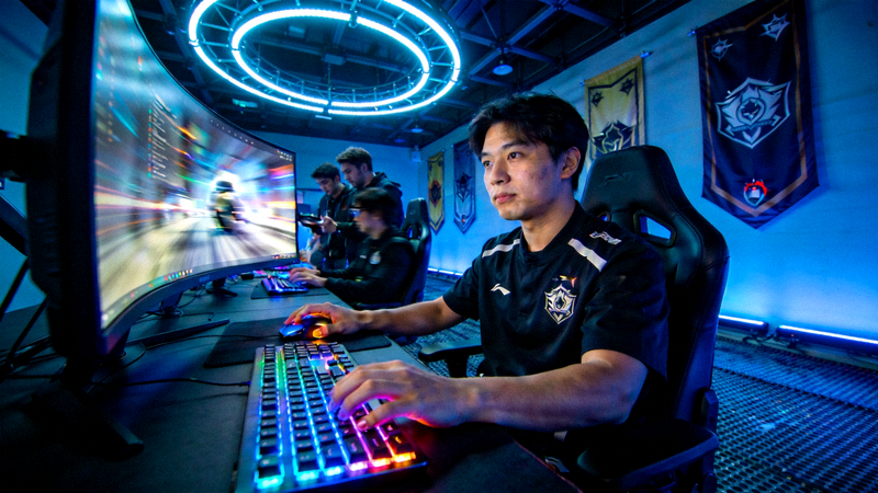 电竞选手在专业比赛场馆内专注操作键盘和鼠标的画面